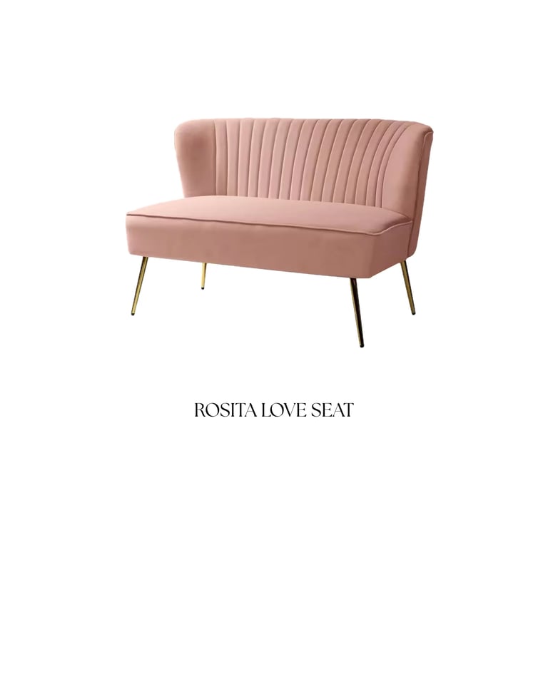 Rose pink velvet loveseat with vertical channel stitching and gold and black metal legs