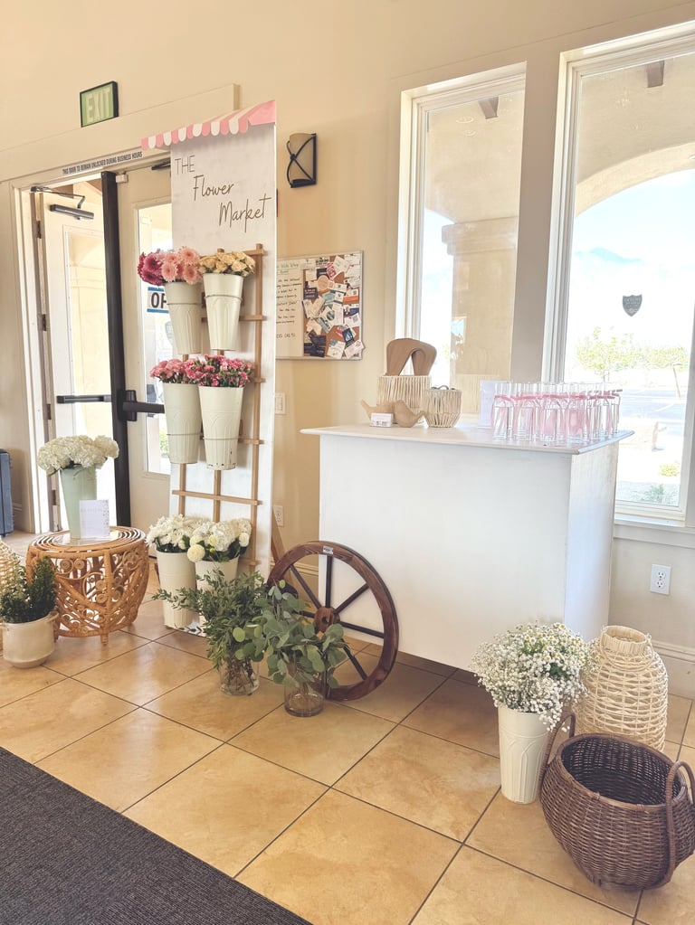 Charming flower market shop interior with pink-striped awning, white counter, potted flowers, vintage wagon wheel