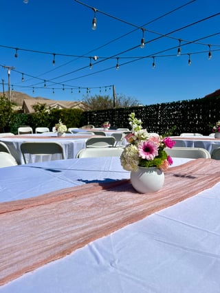 Outdoor event venue with white-draped tables