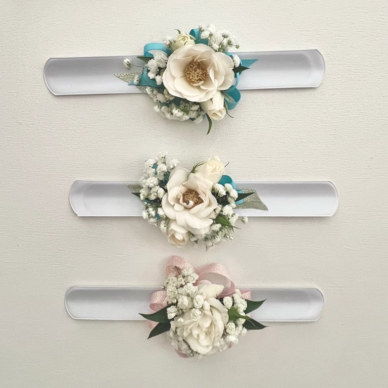 Three decorative wall bands with white flowers, greenery, and teal or pink accents arranged vertically