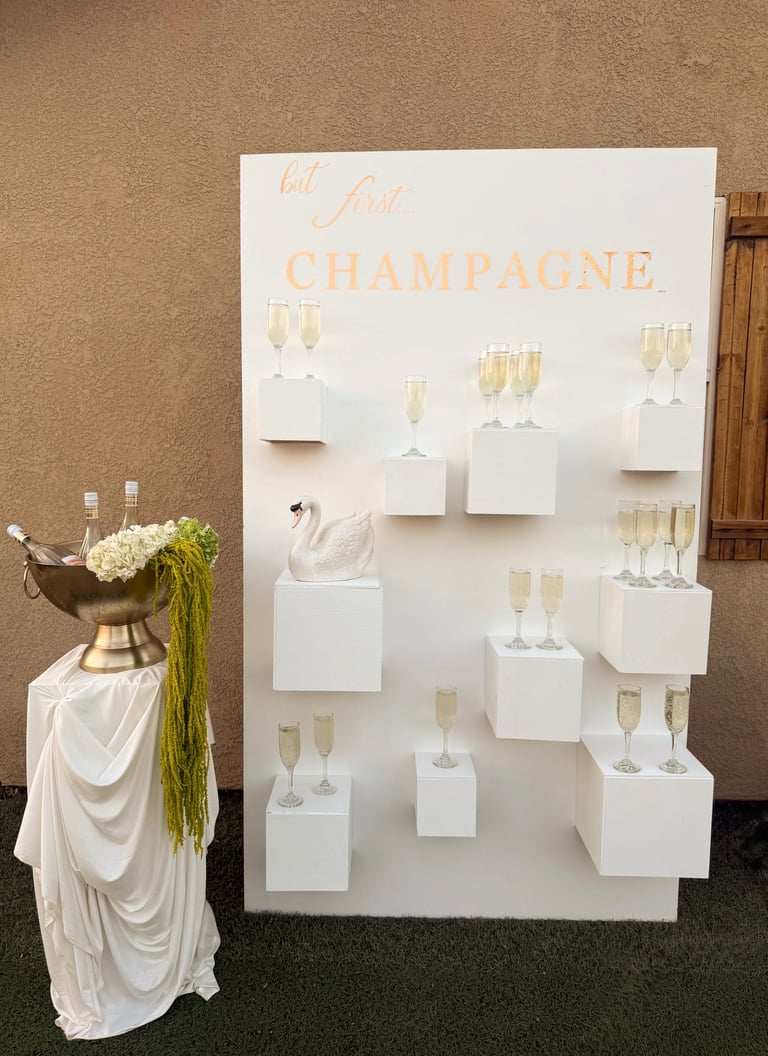 Elegant champagne display with white wall-mounted backdrop