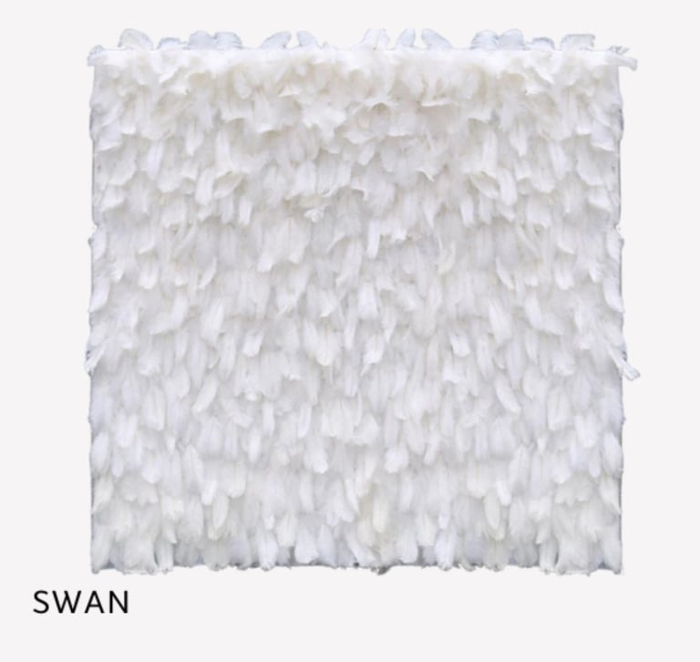 White ruffled fabric backdrop labeled Swan with layered texture